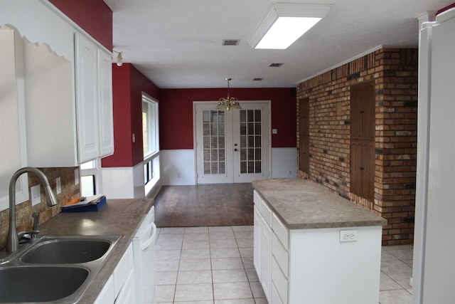 kitchen with sink, french doors, light hardwood / wood-style flooring, a notable chandelier, and white cabinets