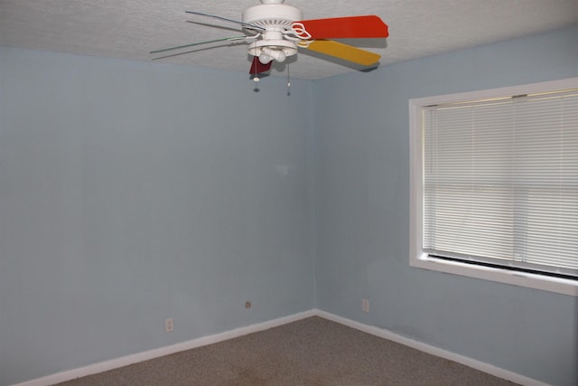 carpeted empty room featuring ceiling fan and a textured ceiling