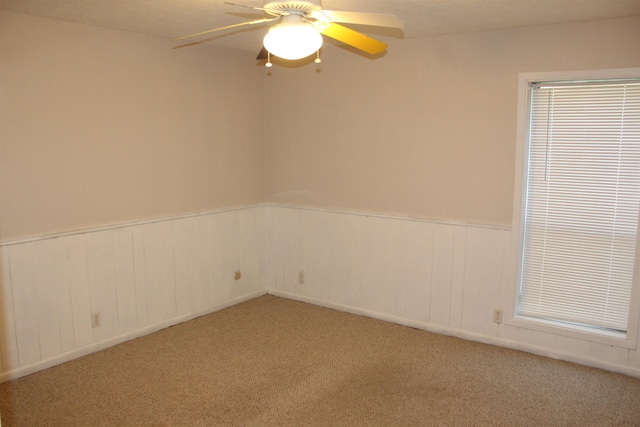 carpeted spare room with a textured ceiling and ceiling fan