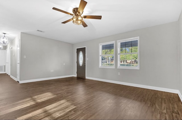 interior space with ceiling fan with notable chandelier and dark hardwood / wood-style flooring