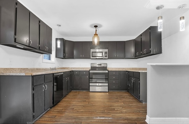 1411 Ryan Chapel Rd, Diboll, TX 75941 - kitchen with stainless steel appliances, dark wood-style flooring, light countertops, and decorative light fixtures