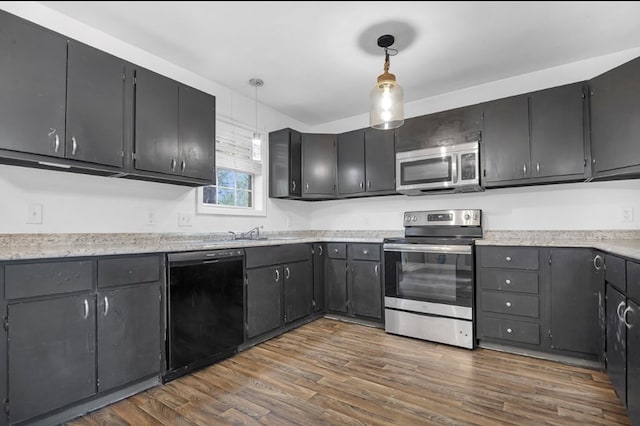 1411 Ryan Chapel Rd, Diboll, TX 75941 - kitchen featuring stainless steel appliances, dark wood finished floors, decorative light fixtures, and light countertops