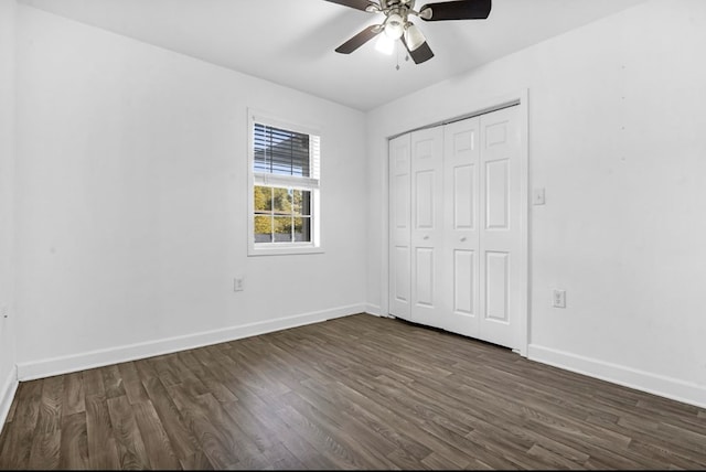 unfurnished bedroom with dark hardwood / wood-style flooring, a closet, and ceiling fan