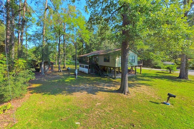 119 W Creekside Dr, Hemphill, TX 75948 - view of yard featuring an outdoor structure, a storage unit, a carport, and driveway