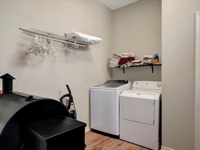 laundry room with light wood-type flooring and washing machine and dryer