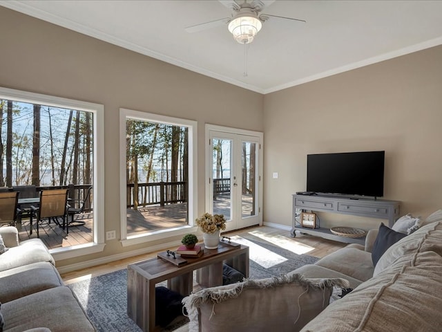 living room with light wood-type flooring, ceiling fan, and crown molding