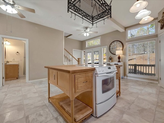 kitchen featuring electric range, french doors, a kitchen island, and a healthy amount of sunlight