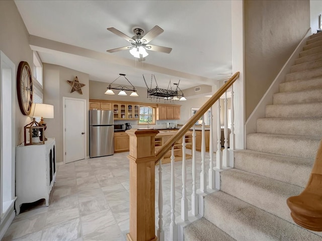 stairs with ceiling fan and sink