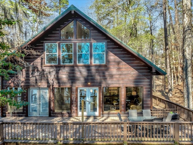 rear view of property with a deck and french doors