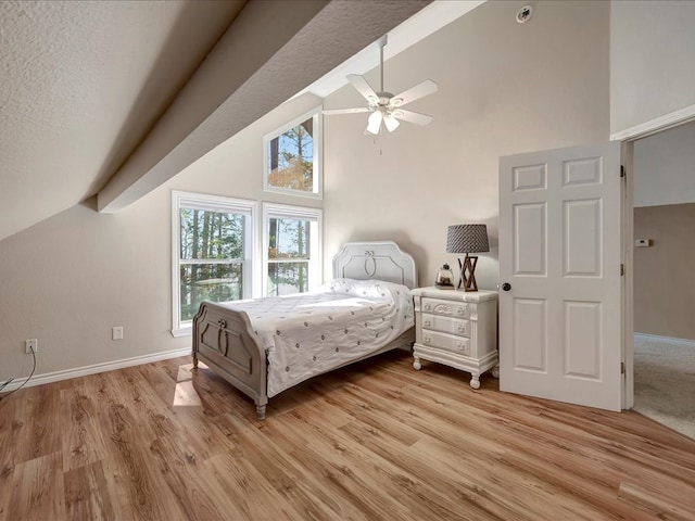 bedroom featuring light hardwood / wood-style flooring, high vaulted ceiling, and ceiling fan