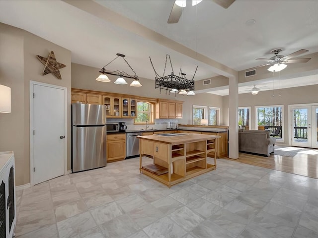 kitchen with backsplash, stainless steel appliances, plenty of natural light, and ceiling fan