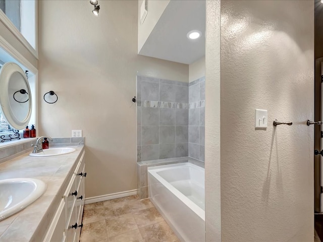 bathroom featuring a bathing tub, vanity, a wealth of natural light, and tile patterned flooring