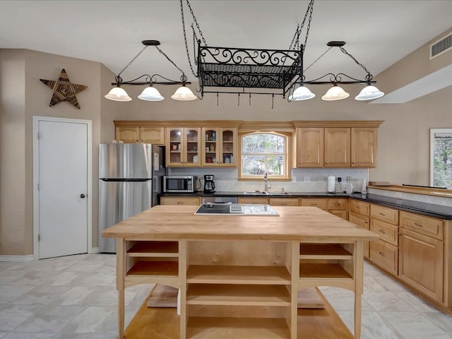 kitchen featuring light brown cabinets, sink, decorative backsplash, appliances with stainless steel finishes, and butcher block counters