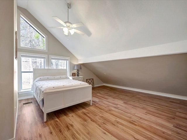 bedroom with ceiling fan, light hardwood / wood-style flooring, and lofted ceiling