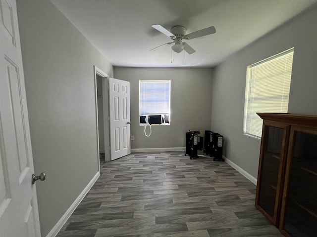 interior space featuring ceiling fan, cooling unit, and dark wood-type flooring