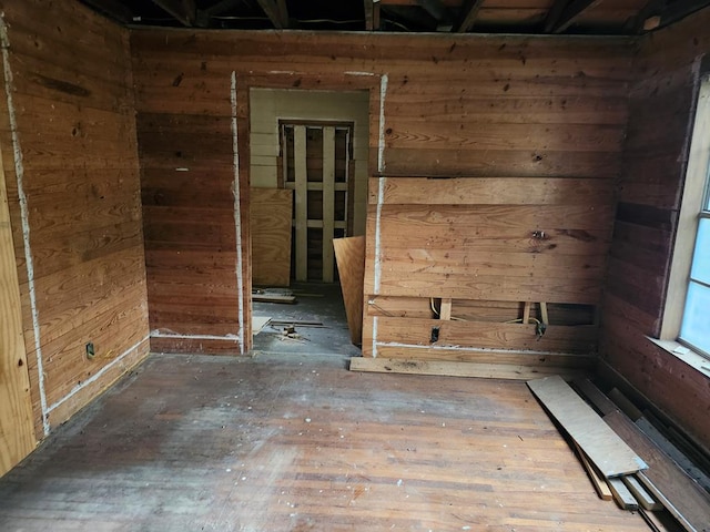 empty room featuring wood walls and hardwood / wood-style floors