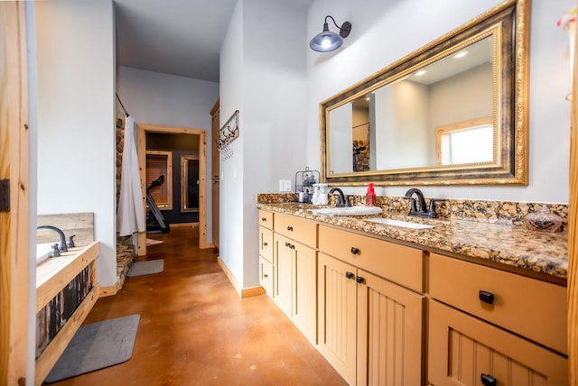 bathroom featuring a bath, finished concrete flooring, vanity, and baseboards