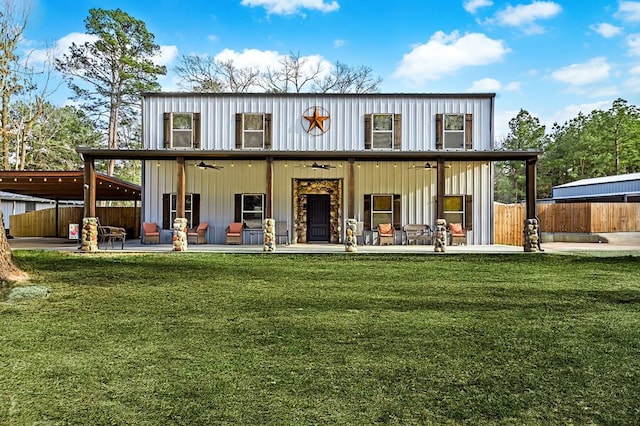 exterior space featuring board and batten siding, a front lawn, ceiling fan, fence, and a patio area