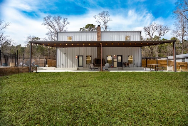 back of house with a yard, fence, and a chimney