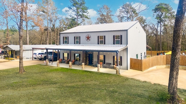 view of front of house featuring a front yard, fence, and metal roof