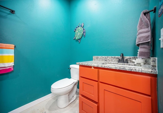 bathroom with baseboards, toilet, and vanity