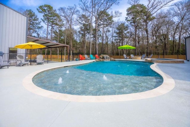 view of pool with a pool with connected hot tub, a fenced backyard, and a patio area