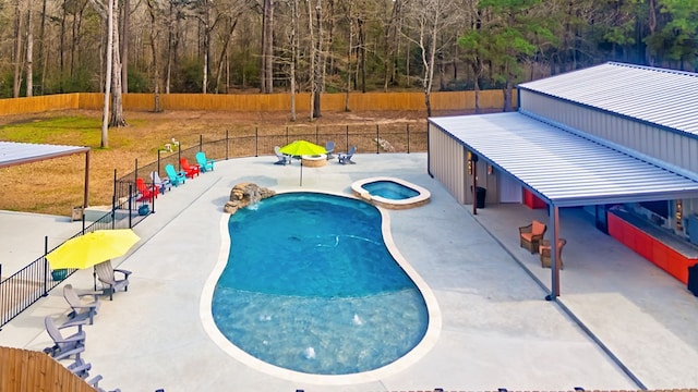 view of swimming pool featuring a patio, fence, and a pool with connected hot tub