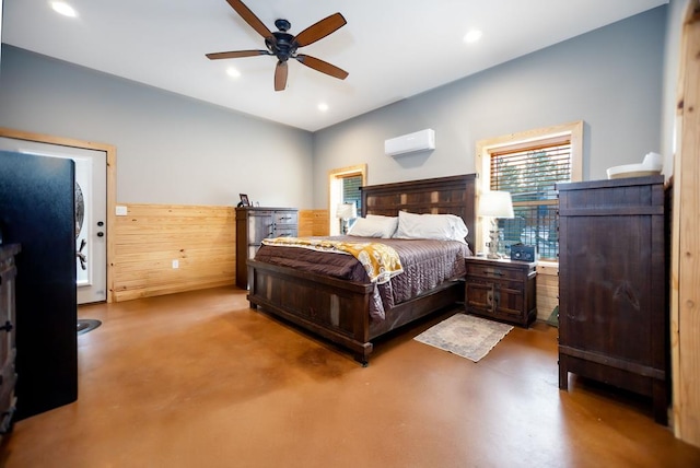 bedroom featuring recessed lighting, finished concrete floors, a ceiling fan, and a wall unit AC