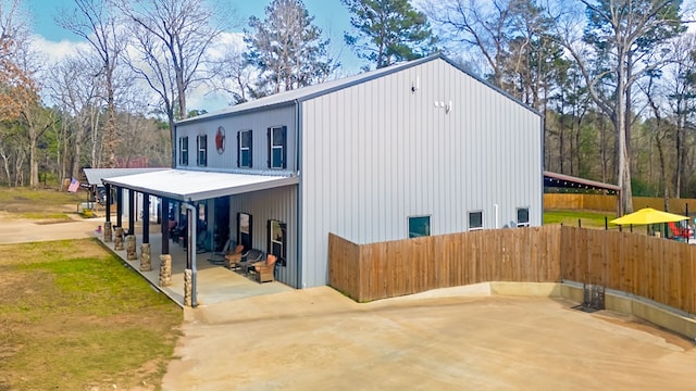 view of property exterior with a patio and fence