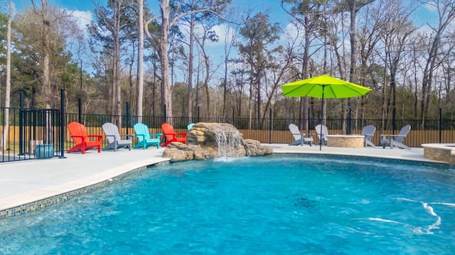 view of swimming pool featuring a patio area, a fenced in pool, a fire pit, and fence