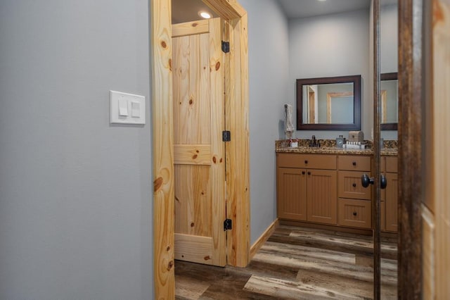 hallway with baseboards and dark wood-style flooring