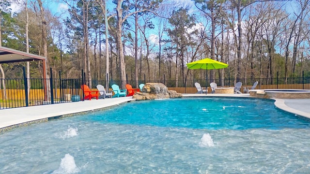 view of swimming pool featuring a patio area, fence, and a pool with connected hot tub