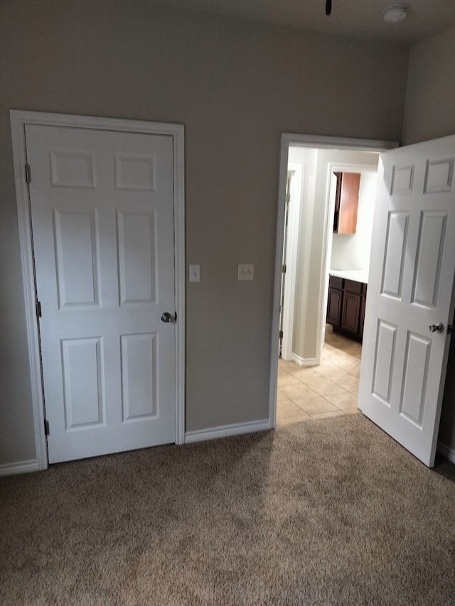 unfurnished bedroom with light carpet and ensuite bathroom