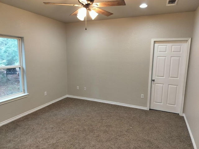 empty room featuring dark carpet and ceiling fan