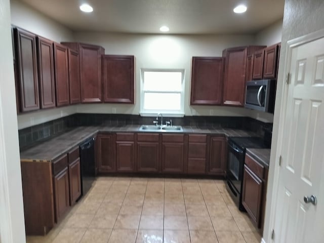 kitchen featuring light tile patterned flooring, sink, and black appliances