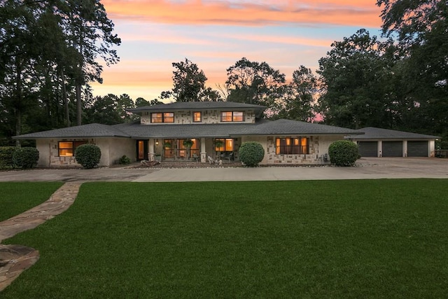 1025 Creek Bend Dr, Jasper, TX 75951 - rear view of house with curved driveway, a yard, stone siding, and a garage