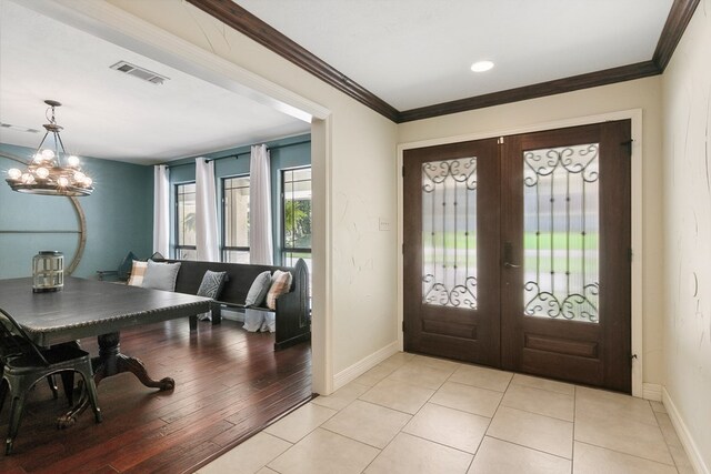 1025 Creek Bend Dr, Jasper, TX 75951 - entryway featuring french doors, a chandelier, ornamental molding, and light tile patterned floors
