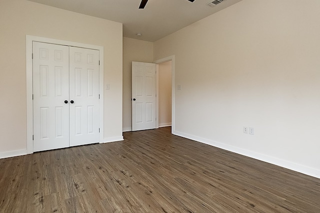 unfurnished bedroom featuring a closet, ceiling fan, and dark hardwood / wood-style flooring