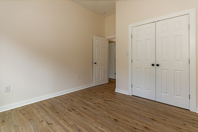 unfurnished bedroom featuring wood-type flooring and a closet