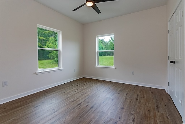 spare room featuring dark hardwood / wood-style flooring, ceiling fan, and plenty of natural light