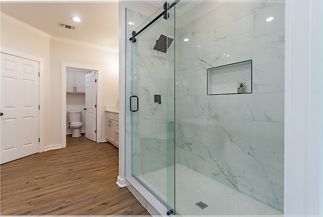 bathroom featuring walk in shower, toilet, ornamental molding, and hardwood / wood-style flooring