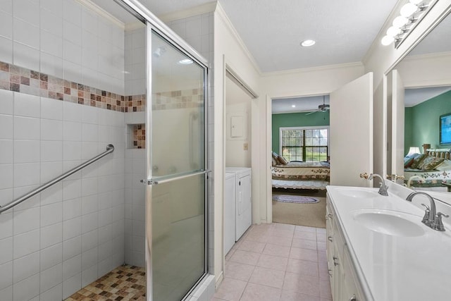 bathroom featuring tile patterned flooring, washer / clothes dryer, crown molding, and a shower with shower door