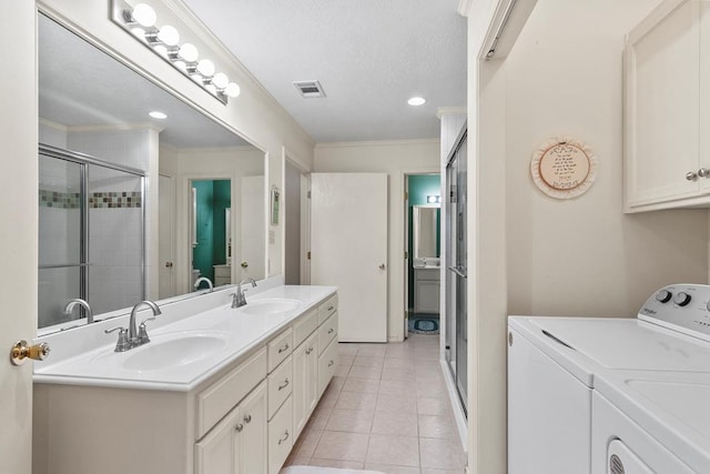 bathroom featuring ornamental molding, separate washer and dryer, tile patterned floors, and vanity