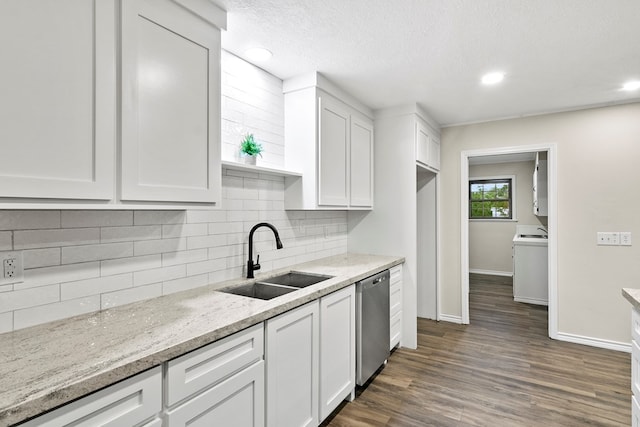 kitchen with white cabinetry, sink, stainless steel dishwasher, and light stone counters