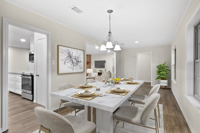 dining room featuring dark wood-type flooring, crown molding, and an inviting chandelier