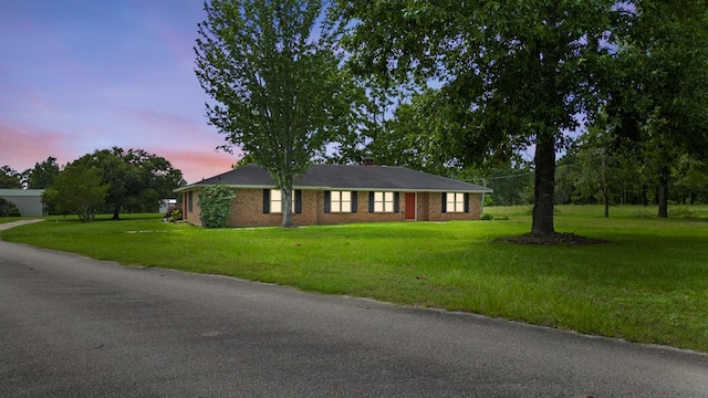 ranch-style home featuring a lawn