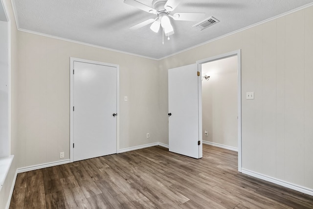 unfurnished room featuring hardwood / wood-style flooring, crown molding, a textured ceiling, and ceiling fan