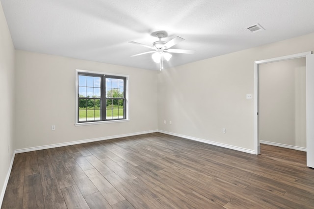 spare room with dark hardwood / wood-style flooring, ceiling fan, and a textured ceiling