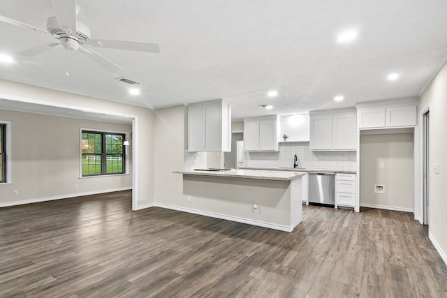 kitchen featuring dark wood-type flooring, backsplash, light stone counters, white cabinets, and stainless steel dishwasher