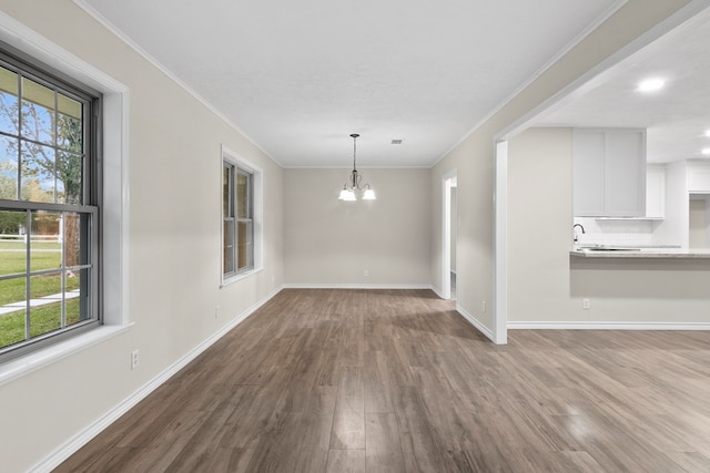 unfurnished dining area featuring hardwood / wood-style flooring, ornamental molding, and a healthy amount of sunlight